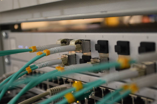 Netwerk switch in rack with blue fiber cables 